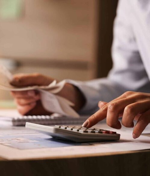 Close-up of business accountant using calculator while working i